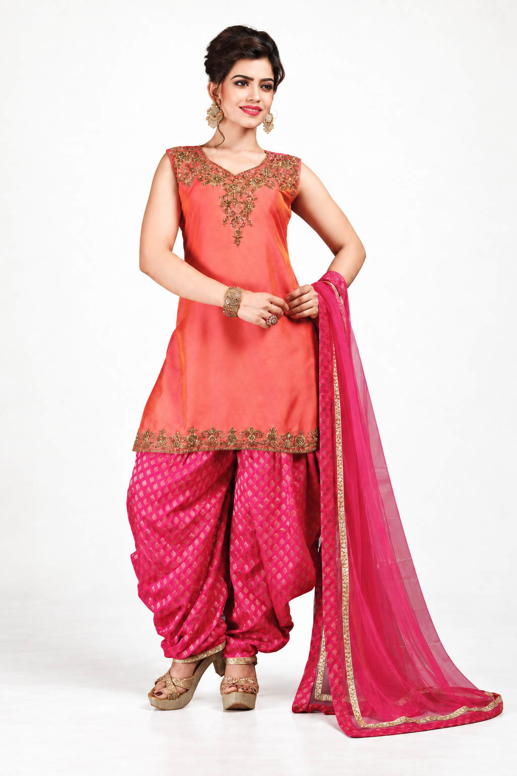 Smiling model wearing a coral and pink embroidered Indian outfit